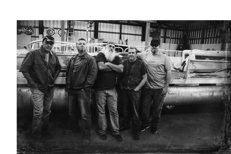 Animal Planet The guys in front of a boat in the shop.