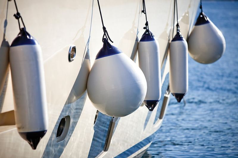 Modern yacht fenders attached with ropes.