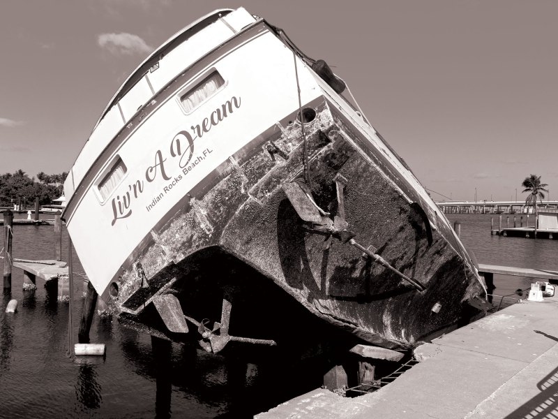 BTG725-Abandoned-Boats-1 Motoryacht resting on top of dock