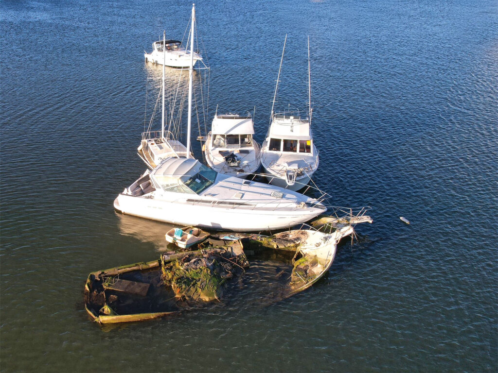 Boats grouped together near sunk vessel