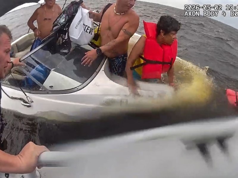 BTG726-Papa-Mac-Rescue-1 Officers rescuing family in sinking boat